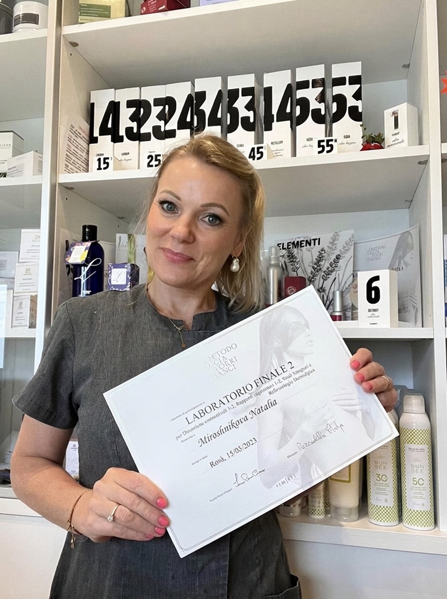 Natalia Miroshnikova sorride nel suo studio con un attestato di formazione