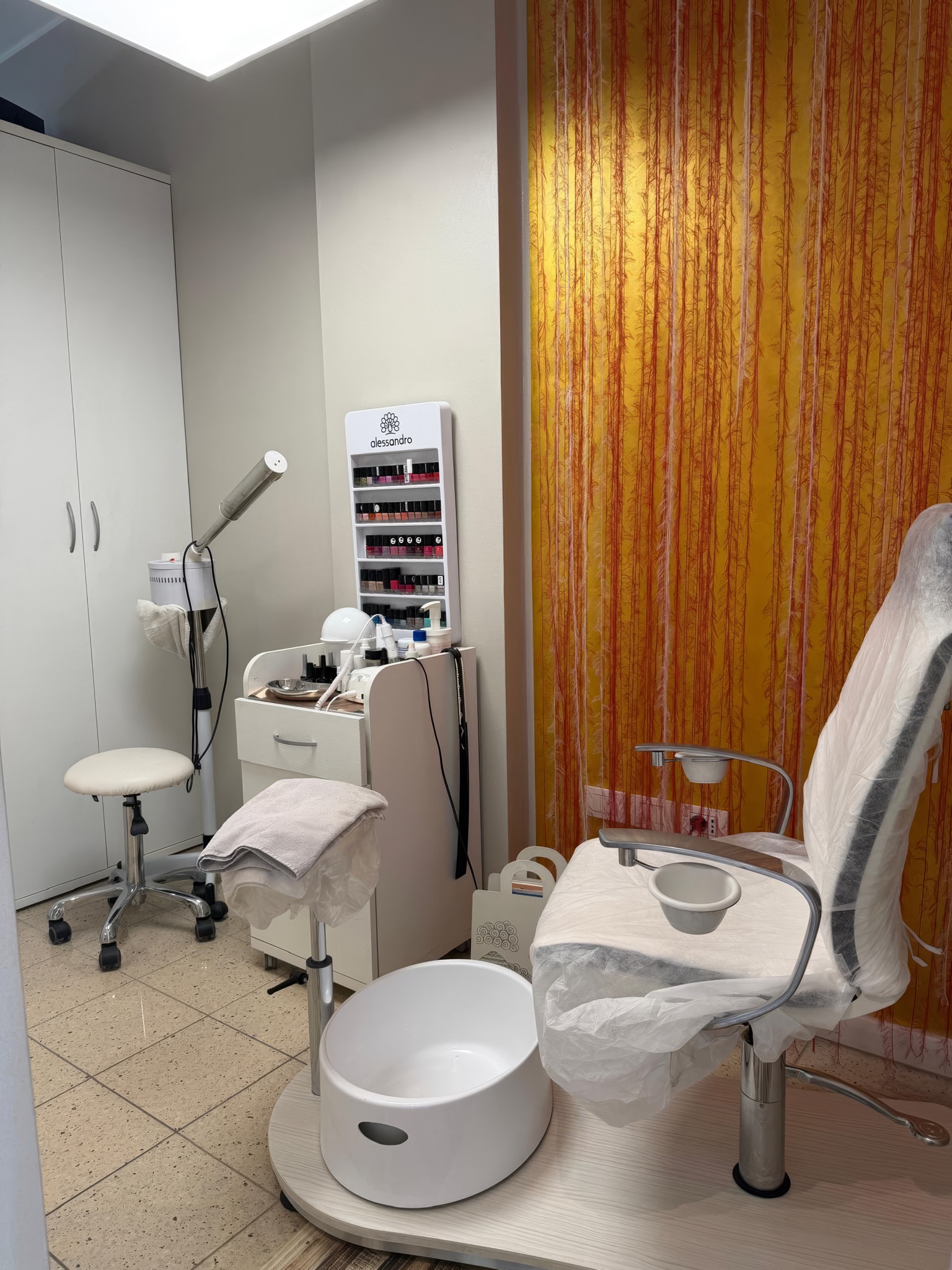 La postazione pedicure con la poltrona e la tenda di filamenti oro