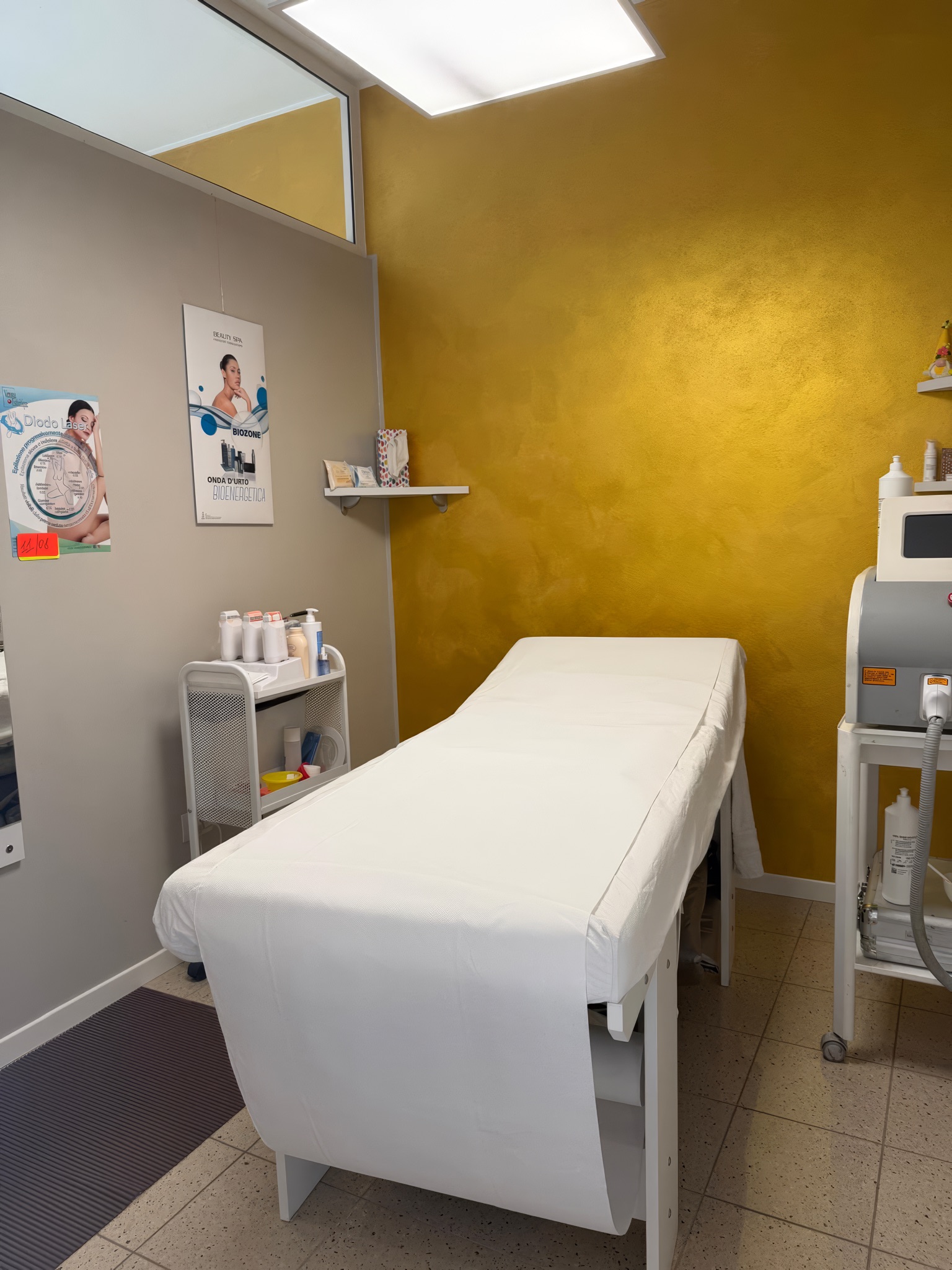 La cabina laser con lettino, parete oro e il diodo laser